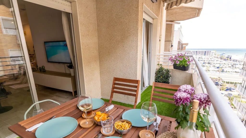 Terraza del apartamento Gaviotas con mesa puesta y vistas al mar y al puerto de Santa Pola