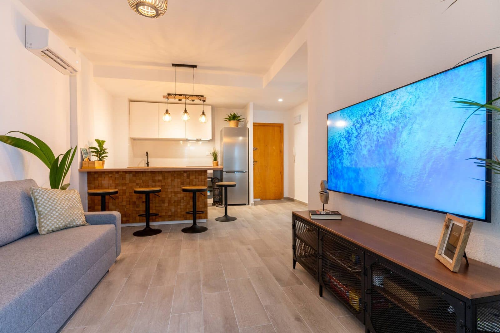 Salón del apartamento Gaviotas 73 con sofá cama, barra de cocina y Smart TV